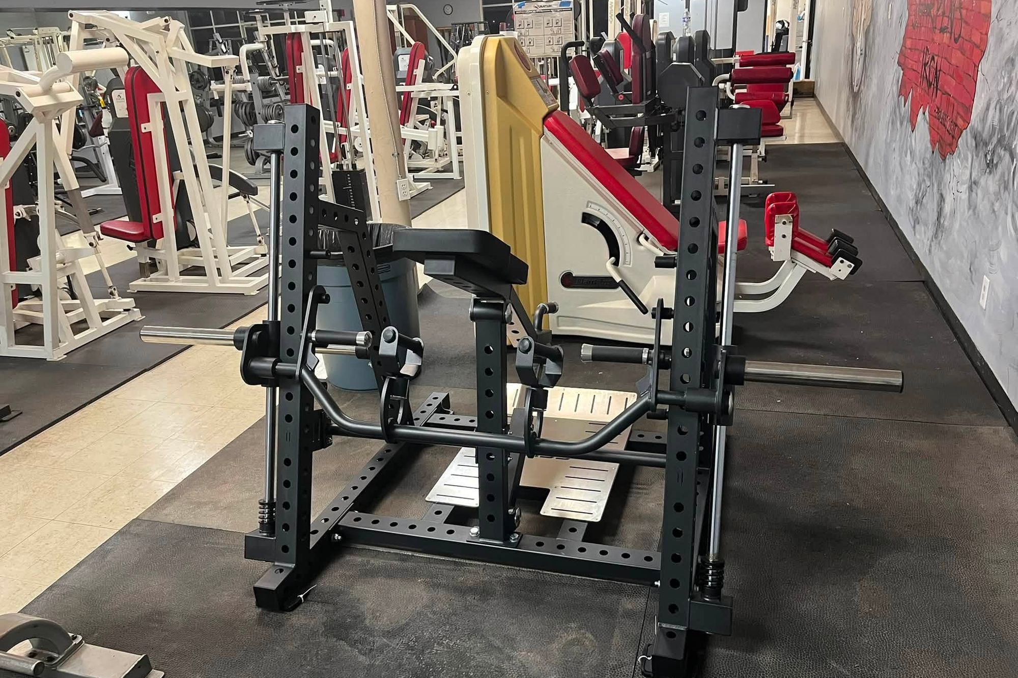 The strength floor at Iron Forge Fitness in Oswego, Kansas, with plate-loaded machines, a leg press and a chest-supported row rack